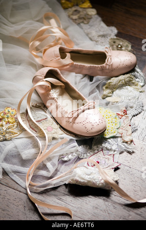 Child's ballet dance shoes on piece of embroidered lace Stock Photo