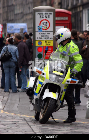 motor cycle policeman getting on his bike in the Royal Mile Edinburgh Scotland Stock Photo