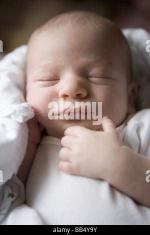 closeup portrait of newborn baby sleeping with hand resting close to his face Stock Photo