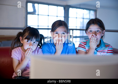 Three little girls secretly watching a video Stock Photo