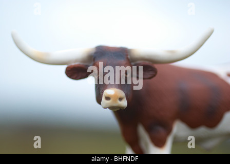 Texas longhorn plastic model cow photographed outside in a field. Stock Photo