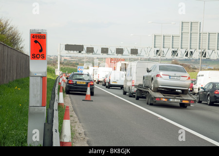 Emergency phone and broken down car on the motorway hard shoulder, M25 , Kent UK Stock Photo