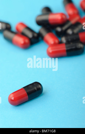 set red and black capsules on blue background . Photo closeup Stock Photo