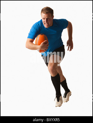 Male rugby player running with ball Stock Photo