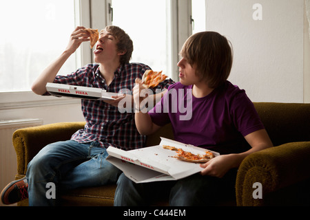 Two boys eating delivery pizza Stock Photo