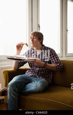 A teenage boy eating delivery pizza Stock Photo