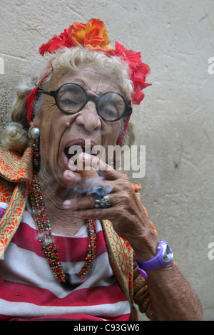 Eccentric elderly Cuban woman Graciela Gonzalez also known as Granny Puretta smokes cigar at age 84 in the historical centre in Havana, Cuba. Stock Photo