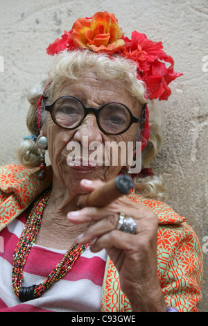 Eccentric elderly Cuban woman Graciela Gonzalez also known as Granny Puretta smokes cigar at age 84 in the historical centre in Havana, Cuba. Stock Photo