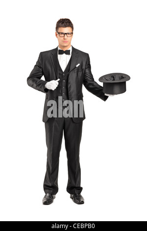 Full length portrait of a magician holding a magic wand and top hat isolated on white background Stock Photo