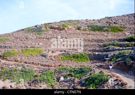 Woman walking on a dirt road near Katapola, on the Greek Cyclade island of Amorgos. Stock Photo