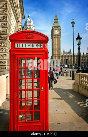 A bright red telephone box in front or Parliament in Westminster Stock Photo