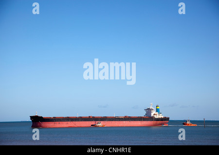 A tugboat pulling a freight ship Stock Photo