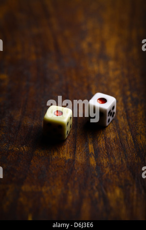 Two dice displaying one on a vintage wood plank Stock Photo