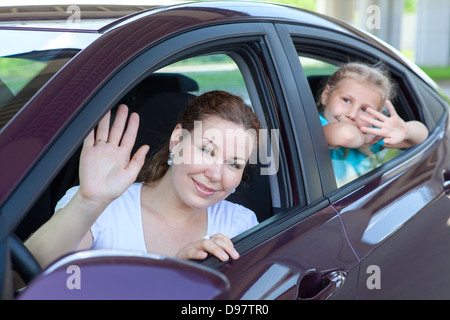 Young mother with little child waving in land vehicle. Caucasian two persons family Stock Photo