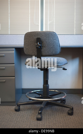 Office chair at empty desk in abandoned office space Stock Photo