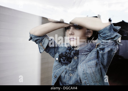 Young woman looking out of window Stock Photo