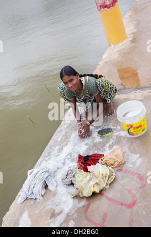 Indian woman washing clothes by hand next to a river. Andhra Pradesh, India Stock Photo