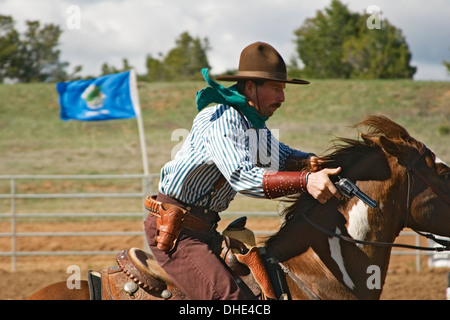 Cowboy with gun on horse, mounted shooting competition, End of Trail Wild West Jubilee, near Albuquerque, New Mexico USA Stock Photo