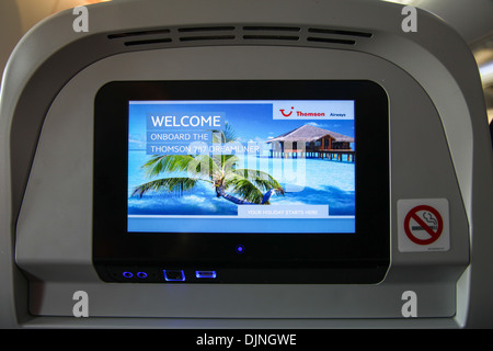 Interior of a Boeing 787 Dreamliner Thompson airways aircraft showing the individual passenger in flight entertainment screen Stock Photo