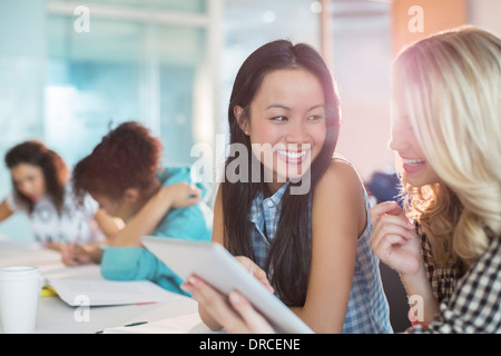 University students using digital tablet in classroom Stock Photo