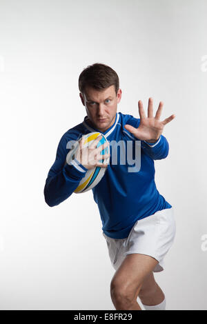 Rugby player running with rugby ball Stock Photo