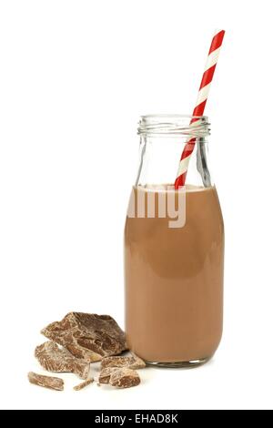 Chocolate milk with straw in traditional bottle with chocolate pieces isolated on white Stock Photo