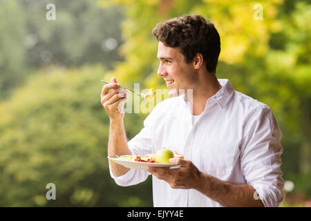 handsome young man eating scrambled egg for breakfast Stock Photo