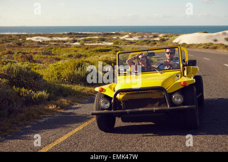 Image of young man and woman in a car going on holiday. Couple on a road trip in car. Stock Photo