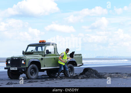 Hartlepool, Cleveland, UK. 28th April 2015. Tony Reid, 22, from Hartlepool forages for Sea-coal that is washed up on the high tide. The tradition has been practiced for centuries on the North East coast but now only a handful of people still keep the tradition going. The coal sells for approx £10 per tonne and is used in coal power stations. Credit:  Robert Smith/Alamy Live News Stock Photo