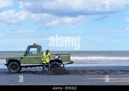 Hartlepool, Cleveland, UK. 28th April 2015. Tony Reid, 22, from Hartlepool forages for Sea-coal that is washed up on the high tide. The tradition has been practiced for centuries on the North East coast but now only a handful of people still keep the tradition going. The coal sells for approx £10 per tonne and is used in coal power stations. Credit:  Robert Smith/Alamy Live News Stock Photo