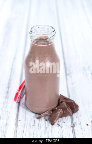 Chocolate Milk in a small bottle (on bright wooden background) Stock Photo