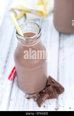 Chocolate Milk in a small bottle (on bright wooden background) Stock Photo