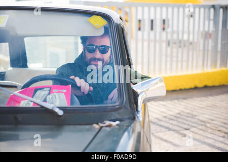 Mid adult man driving vintage car Stock Photo