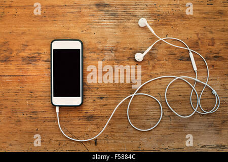 smart phone and earphones on wooden background Stock Photo