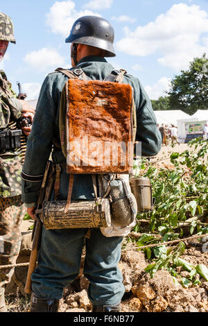 World war two re-enactment. Wehrmacht German soldier, rear view, showing uniform, kit and Poni fur backpack, gas mask canister and water bottle. Stock Photo