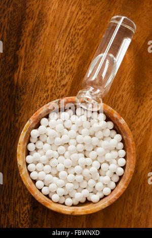 Overhead view of homeopathic medicine consisting of the pills (made from an inert substance) and a bottle of homeopathic liquid. Stock Photo