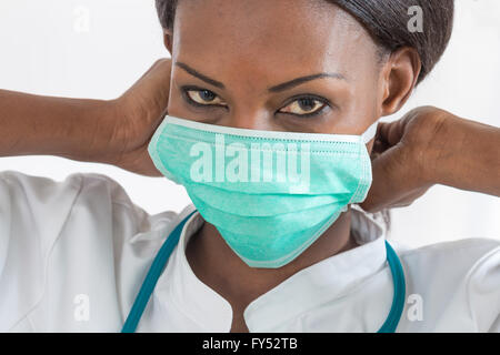 Smiling African American nurse at hospital work station on white background Stock Photo