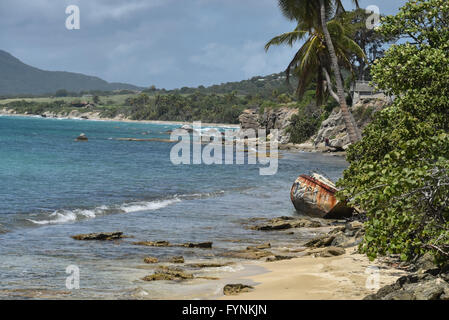 An old rusty boat on an empty beach near the Promenade of Esperanza, a small town on Puerto Rico's Vieques island Stock Photo