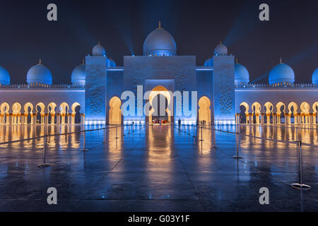 Sheikh Zayed Grand Mosque at Night Covered with Beautiful Blue Lights and light rays Stock Photo