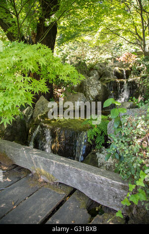 Wooden bridge near a waterfall in a Japanese garden Stock Photo