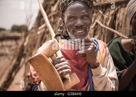 OMORATE, ETHIOPIA - 16 AUGUST 2015:  unidentified old man from Arbore tribe carry in his hands a traditional wooden chair, used Stock Photo