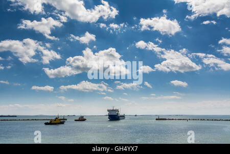 Cargo Ship and Tugboat. Seascape with beautiful sky. Stock Photo