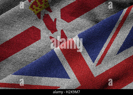 3D rendering of the flags of UK and Northern Ireland on woven fabric texture. Concept of Northern Ireland being part of the UK. Stock Photo