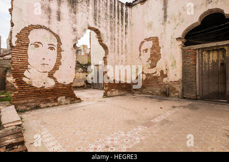 Faces cut into plasterwork on an old wall in Camaguey, Cuba Stock Photo