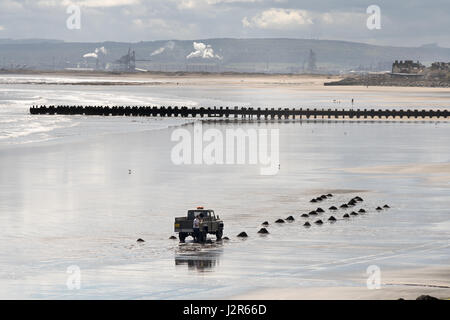 Man collecting sea coal, Seaton Carew, Hartlepool, England, UK Stock Photo