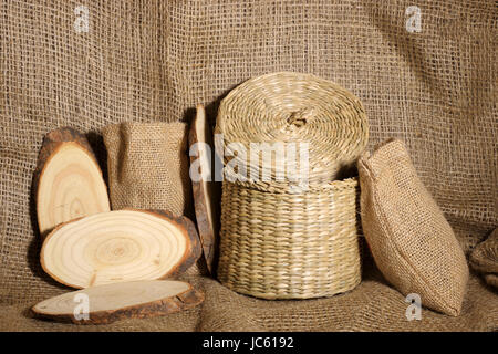 A still life image showing the concept of a Woodland scene with wicker pots and slices of wood Stock Photo