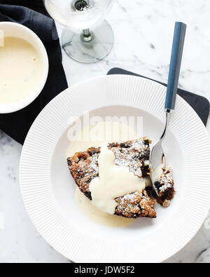 Bowl of bread and butter pudding with custard cream sauce Stock Photo