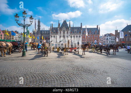 Horse carriages on Grote Markt square in medieval city Brugge at morning, Belgium. Stock Photo