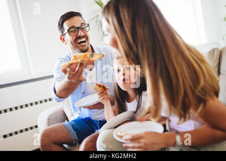 Happy family sharing pizza together at home Stock Photo