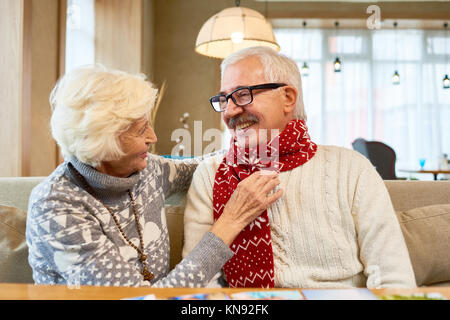 Loving Senior Couple Exchanging Gifts on Christmas Stock Photo